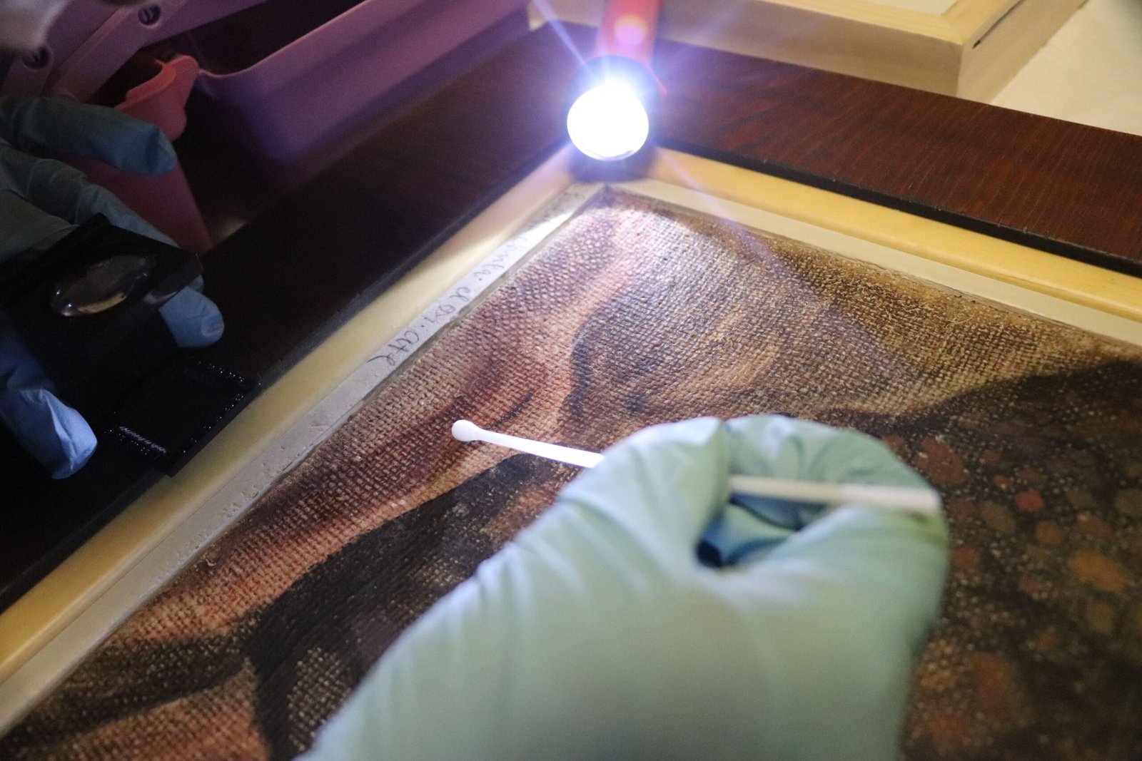 Una mano haciendo limpieza mecánica de una pintura